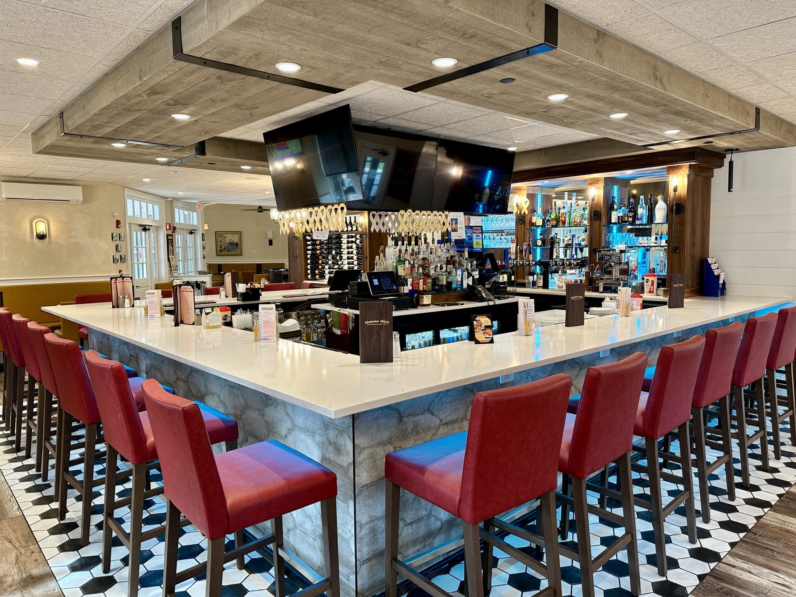 Restaurant bar interior with seating, lighting, and beverage service areas.