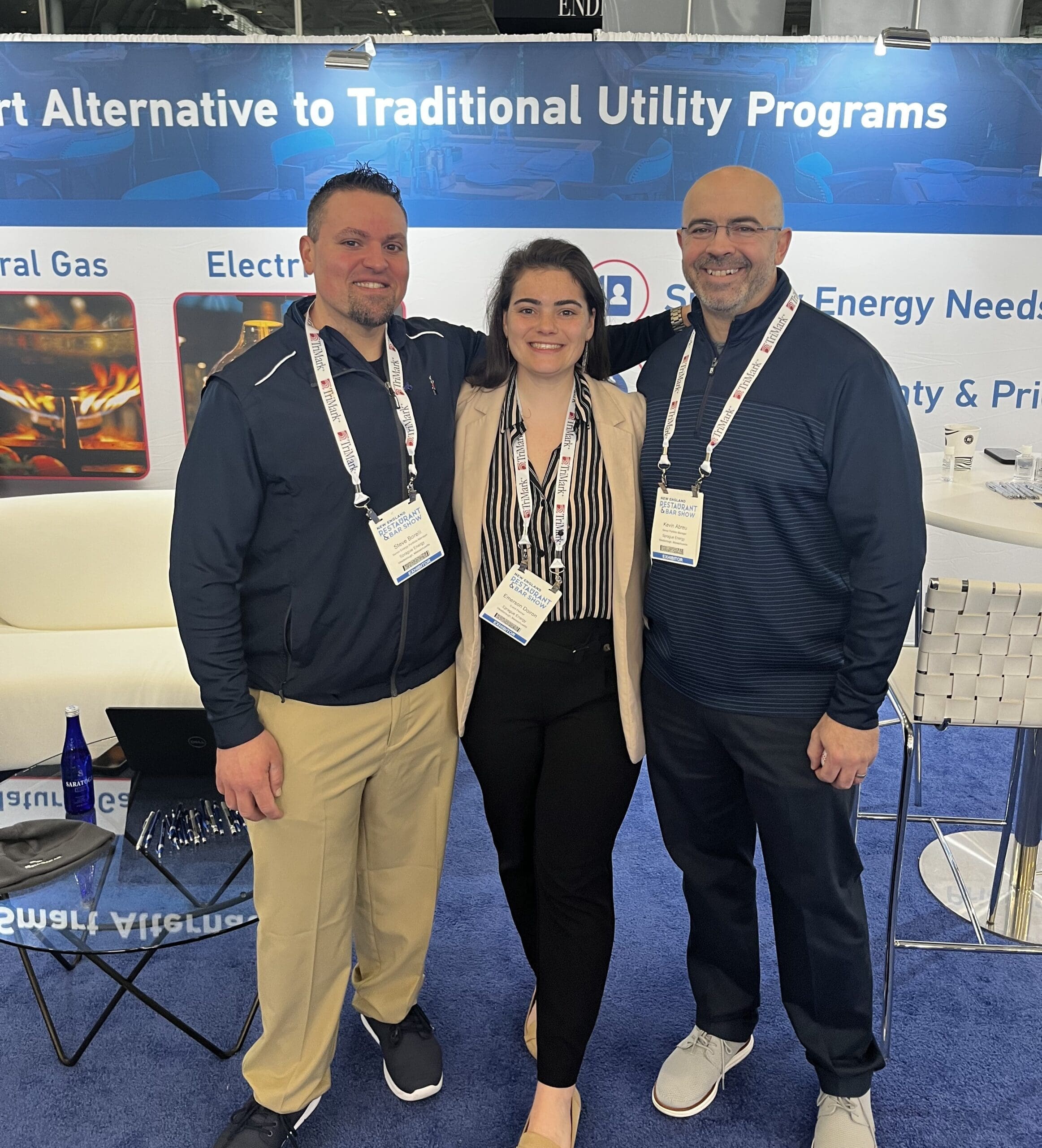 Sprague team members standing together at an industry trade show booth.