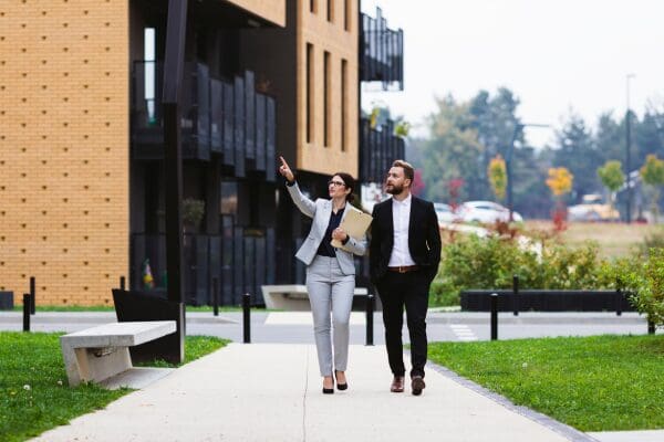 Property managers walking through a residential complex and reviewing buildings.