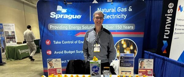 Sprague representative standing at a trade show booth promoting natural gas and electricity solutions.